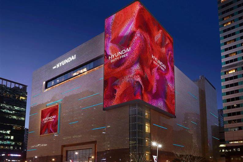 韓國首爾現代免稅店貿易中心分店外觀，夜間呈現現代化設計和燈光效果，突顯其為知名購物地標。