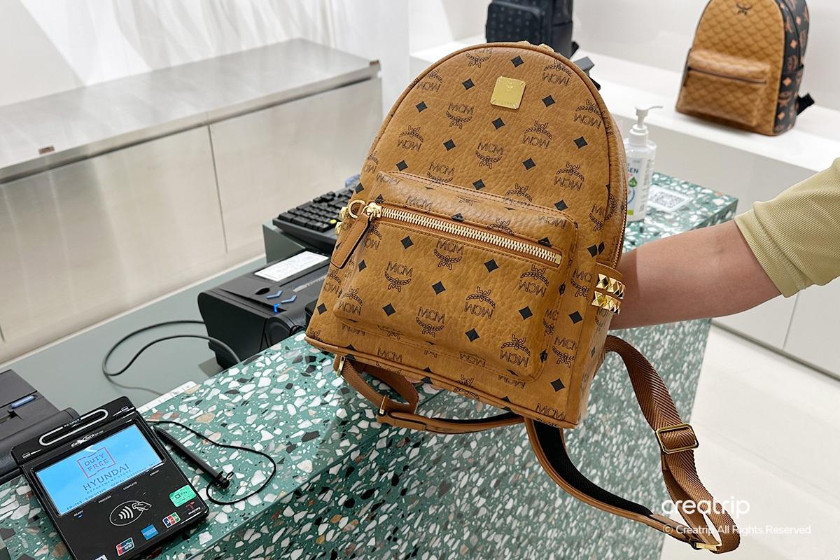 韓國現代免税店的MCM品牌內景,展示奢華揹包及時尚服飾品。