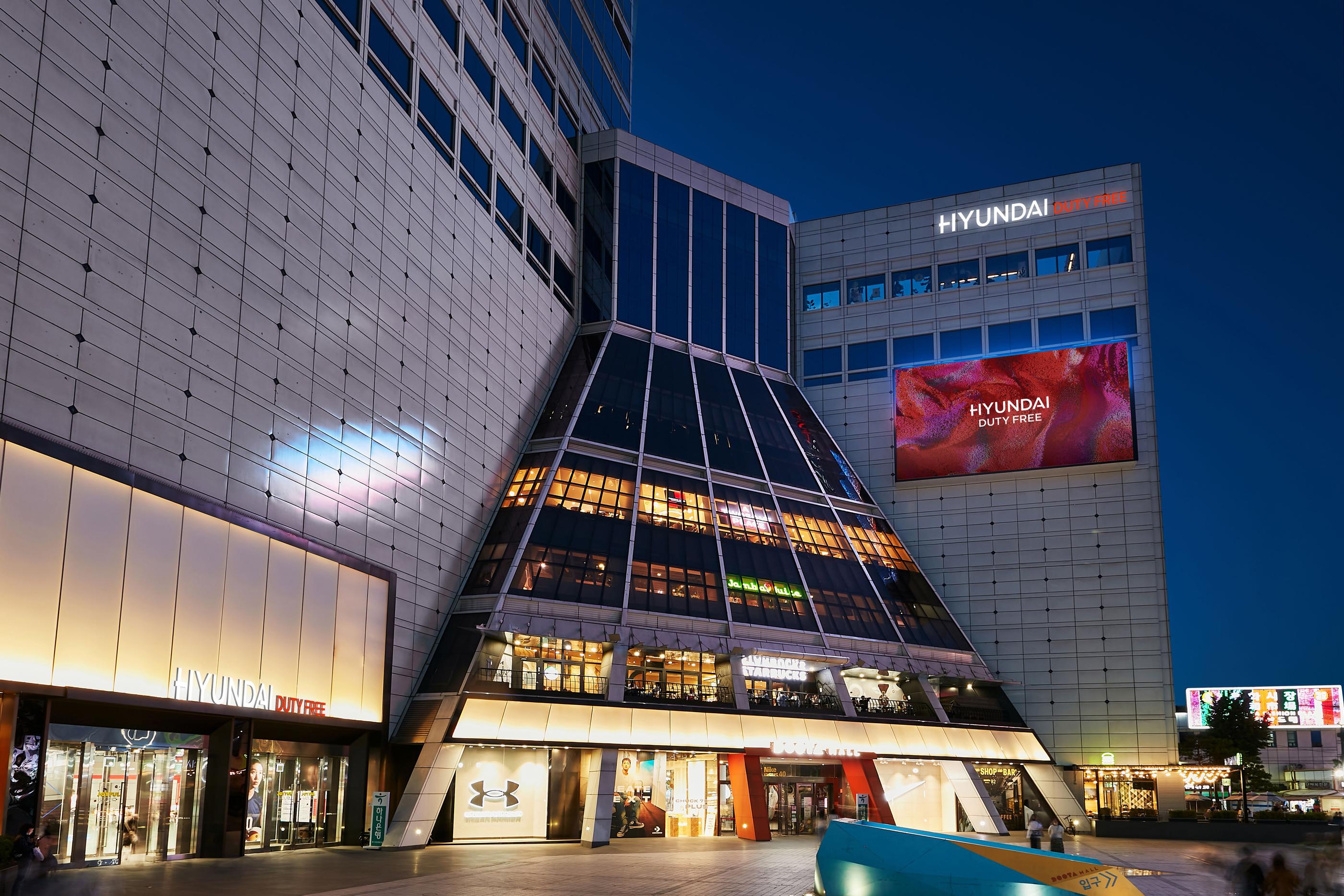 內部現代免稅店東大門分店的購物樓層，展示商品並提供舒適的購物環境，適合喜好時尚與折扣的顧客。