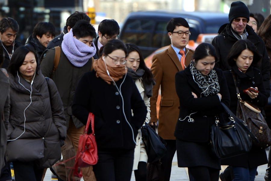 首爾11月的街道場景,熙來攘往的人群穿著冬季服裝,如外套和圍巾,彰顯城市的秋冬季氛圍及氣候變化。