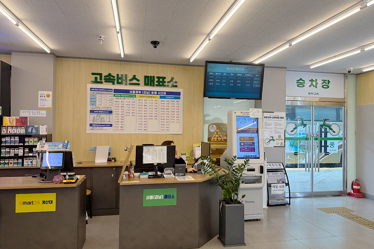 Inside view of a ticketing office at a bus terminal, showcasing the counter and schedules.