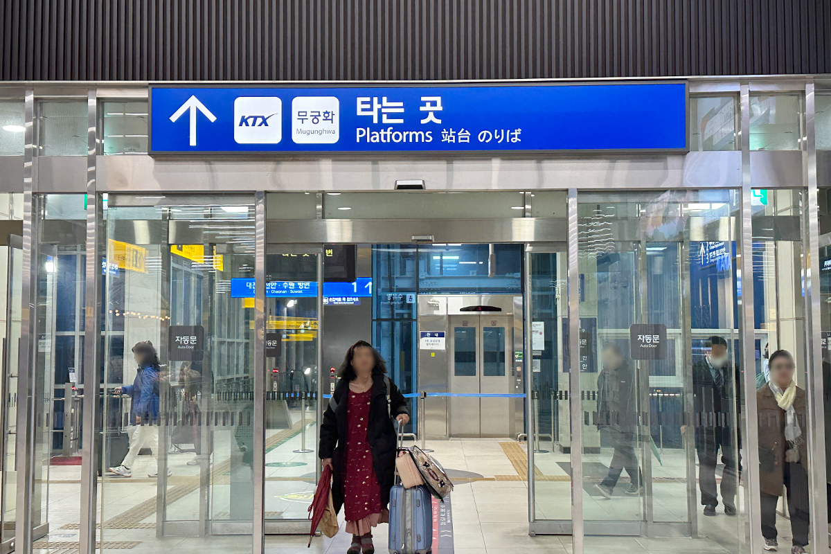 Entrance area of a train station displaying direction signs for platforms serving KTX and Mugunghwa trains.