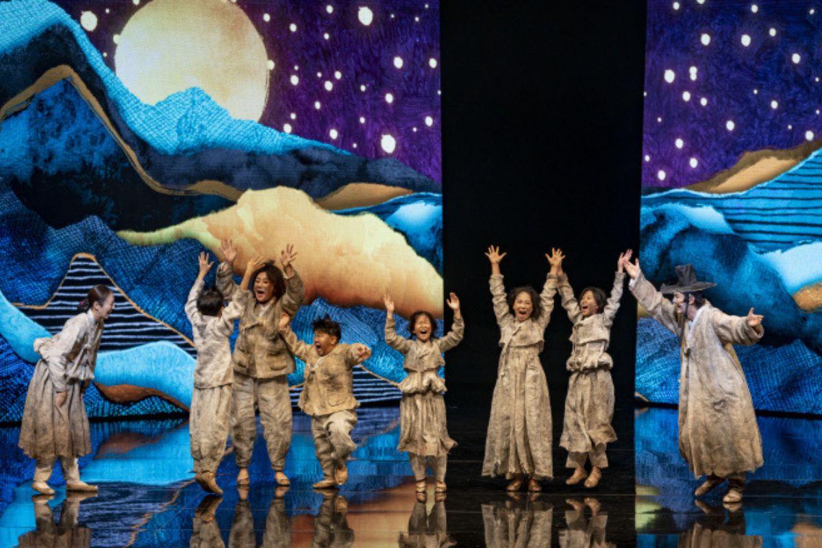 韩国传统戏剧表演，演员在色彩斑斓的舞台背景前跳舞。