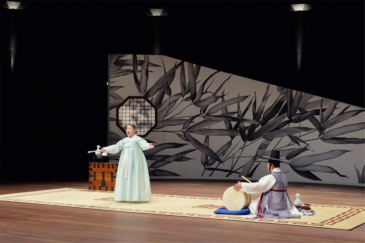 韩国传统盘索里表演场景，演员穿着传统韩服，背景是黑白竹子画。