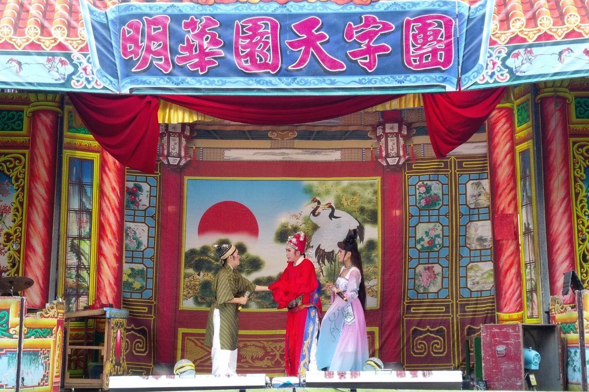 台湾歌仔戏表演，演员身着传统戏服，在丰富装饰的戏台上表演。