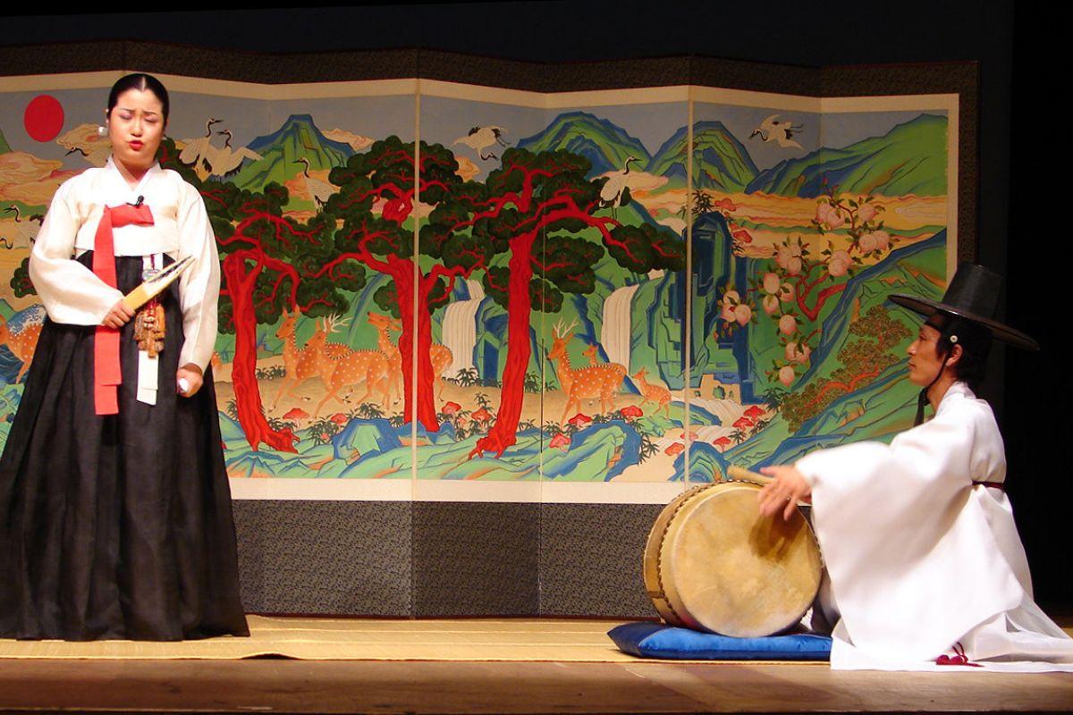 大型盘索里表演，演员身穿华丽的传统服装，舞台背景图案丰富。