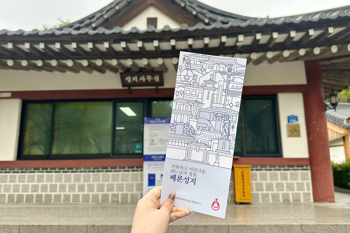 Holding a guide booklet for exploring the historic Baeron Holy Ground in Jecheon