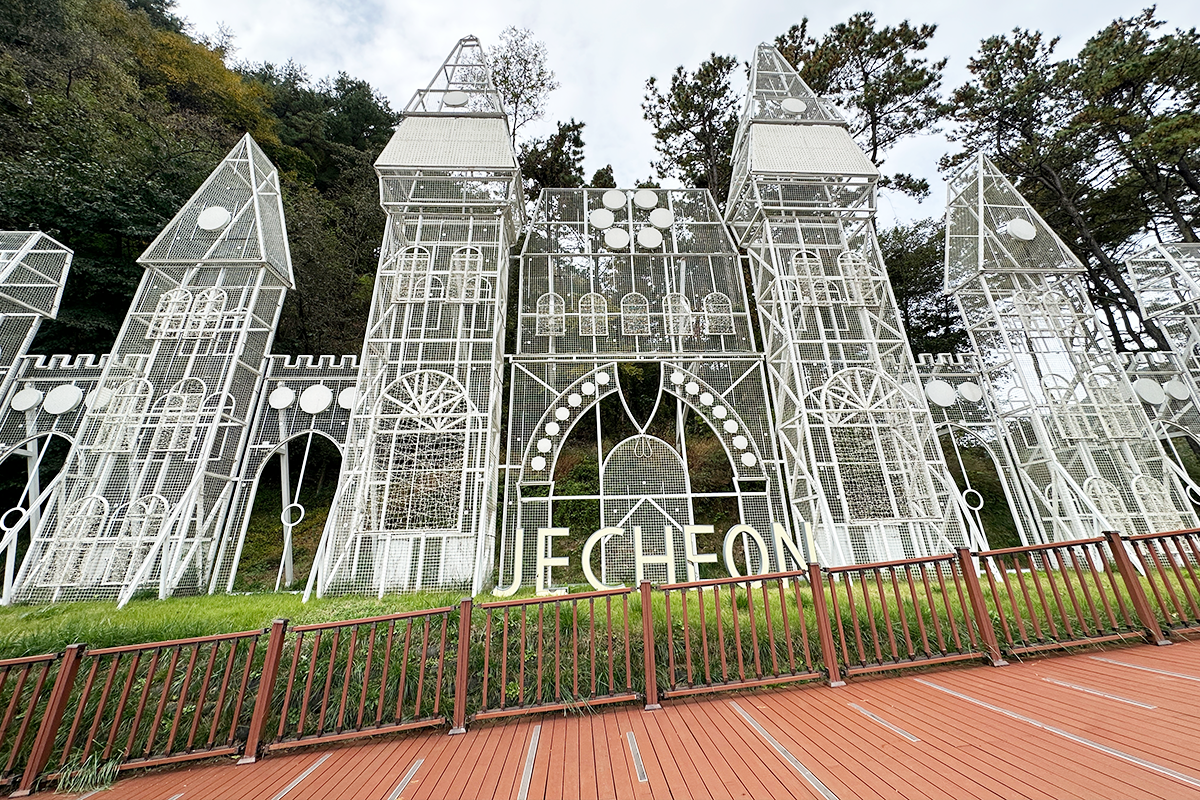 Reflections of a whimsical castle sculpture on the serene waters of Biryongdam Reservoir in Jecheon, South Korea