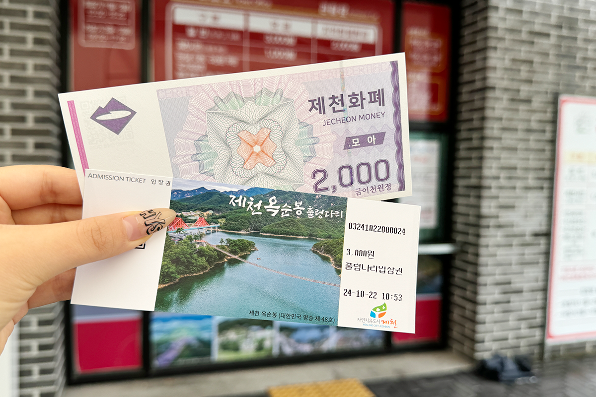 Colorful foliage and mountainous backdrop at Oksunbong Suspension Bridge in clear weather, Jecheon