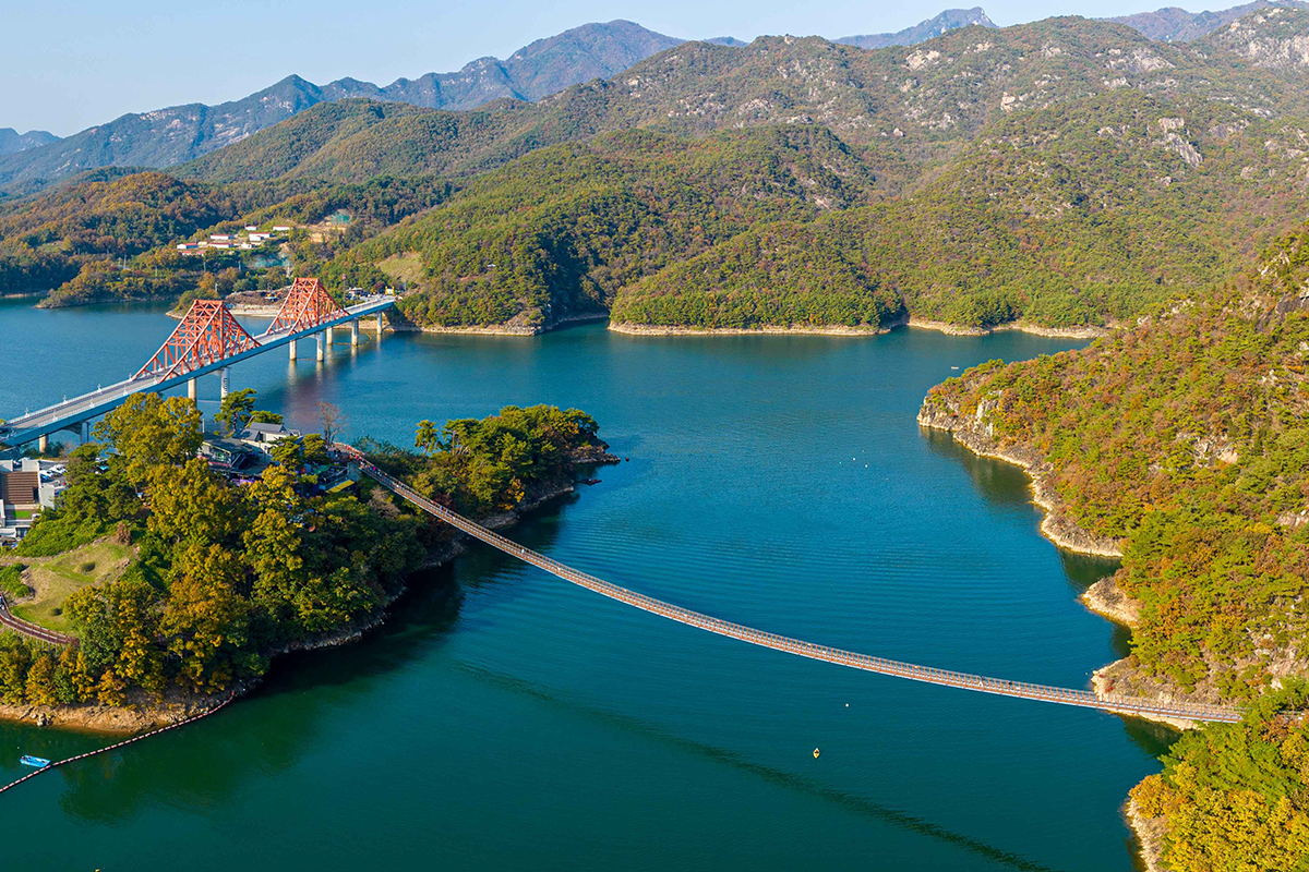 Charming view of Oksundaegyo Bridge and cruise ship on Cheongpung Lake during rainy weather in Jecheon