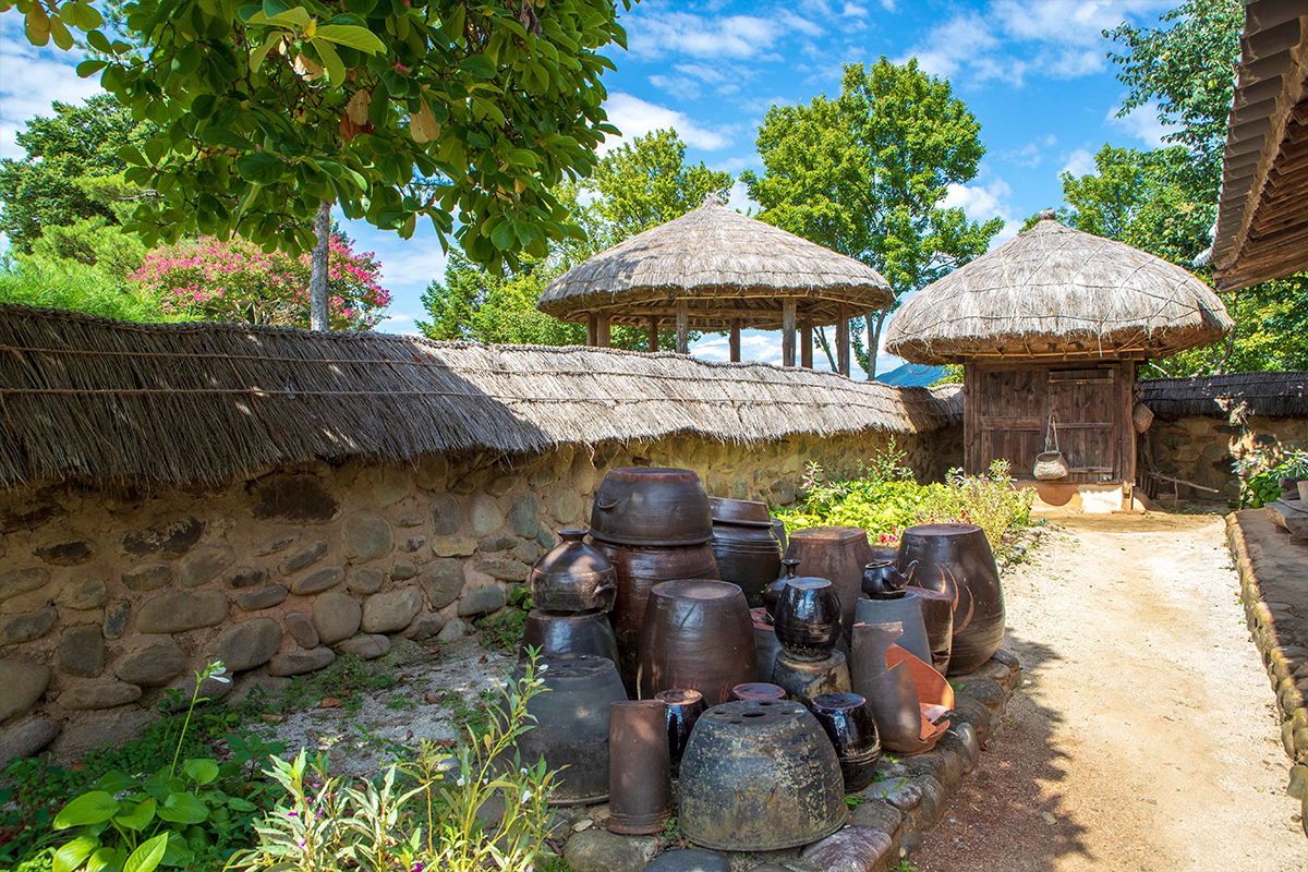 Traditional pottery and straw-roofed storage in a recreated village at Cheongpung Cultural Heritage Complex, Jecheon