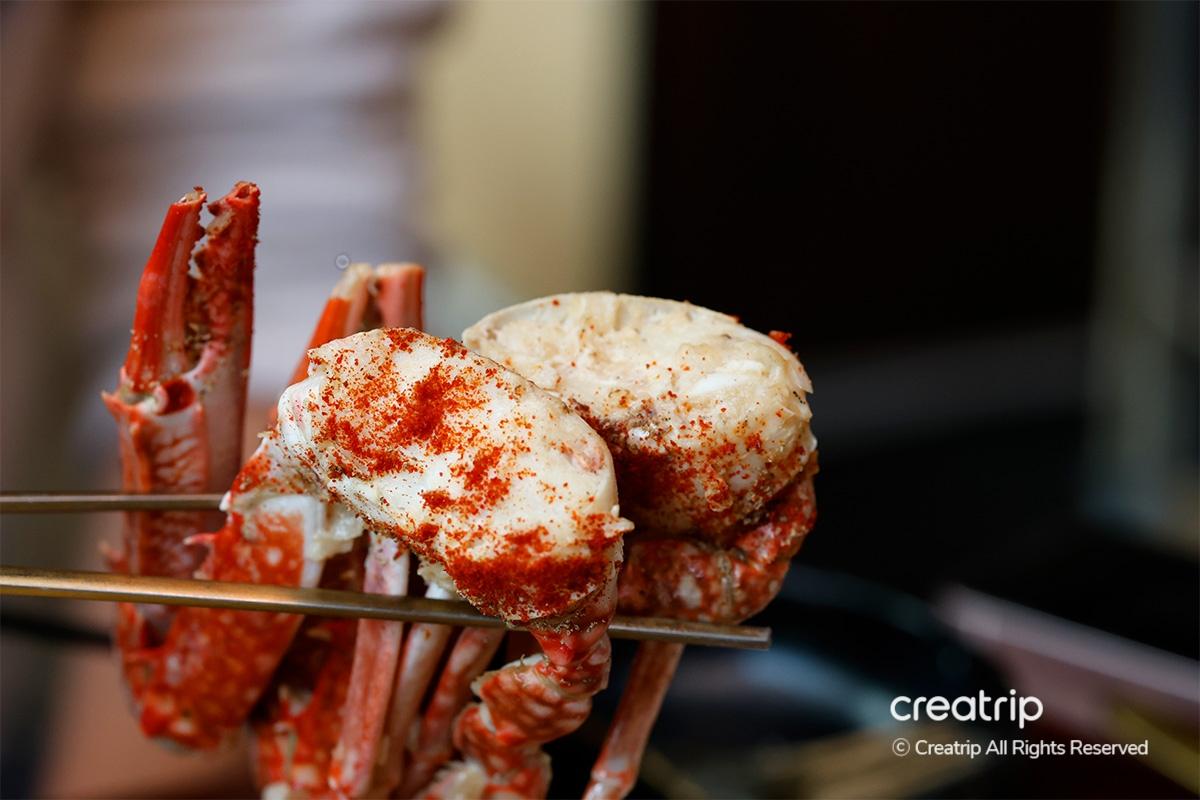 Close-up of two cooked crabs with a sprinkle of red spice at Earl in Hongdae.