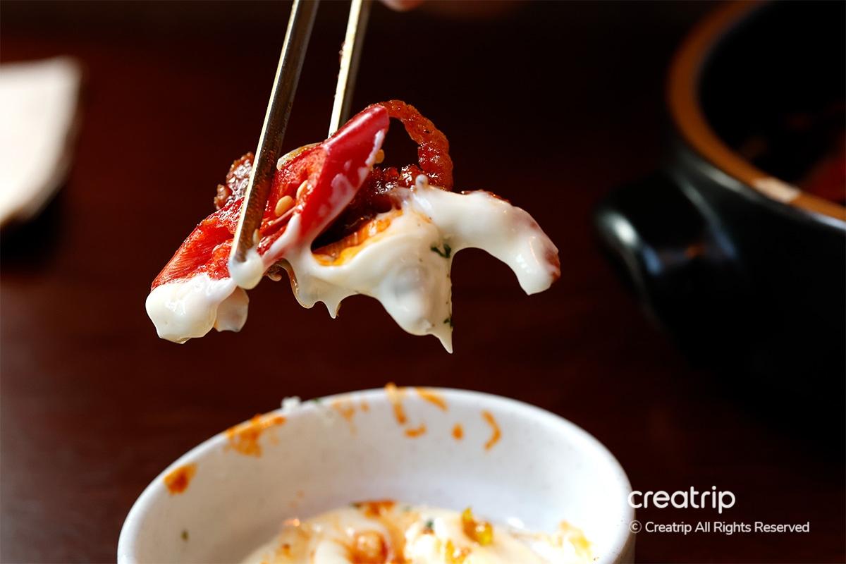 Hand holding a highball glass with a citrus and herbal garnish at Earl, Hongdae.
