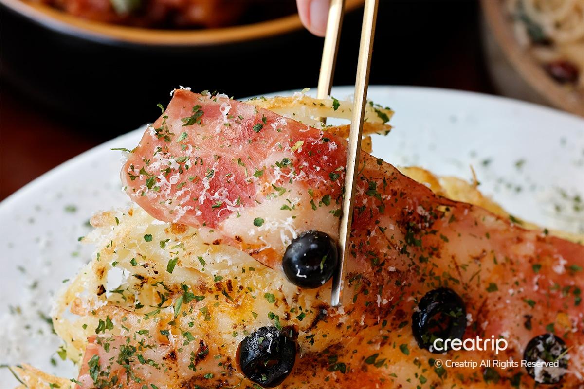 Chopsticks lifting a portion of bacon cheese potato pancake at Earl, Hongdae.