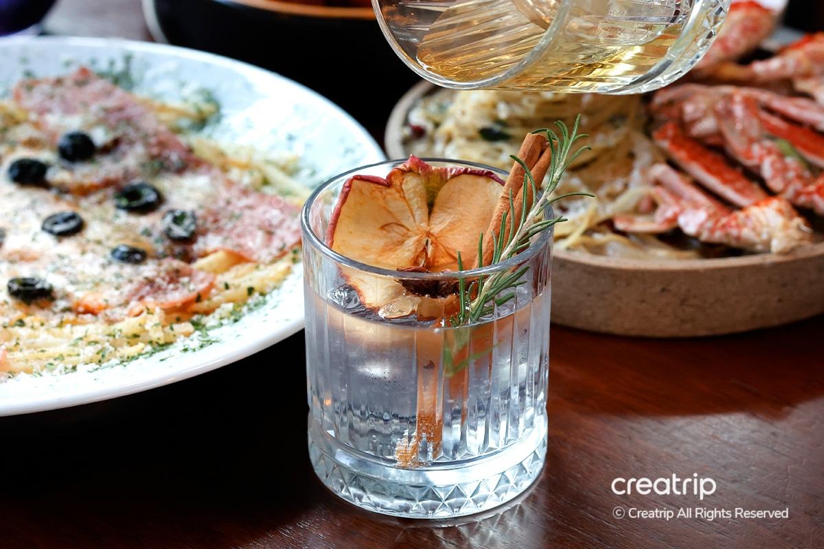 Detailed view of cinnamon stick cocktail infused with herbal garnish at Earl, Hongdae.