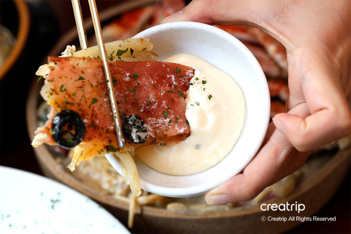 Bacon cheese potato pancake being dipped into creamy sauce at Earl, Hongdae.