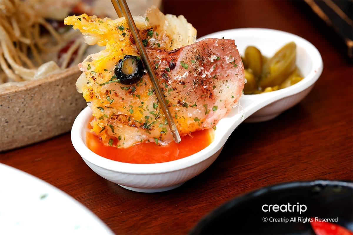 Spicy sauce and pickled jalapenos accompany the bacon cheese potato pancake at Earl.