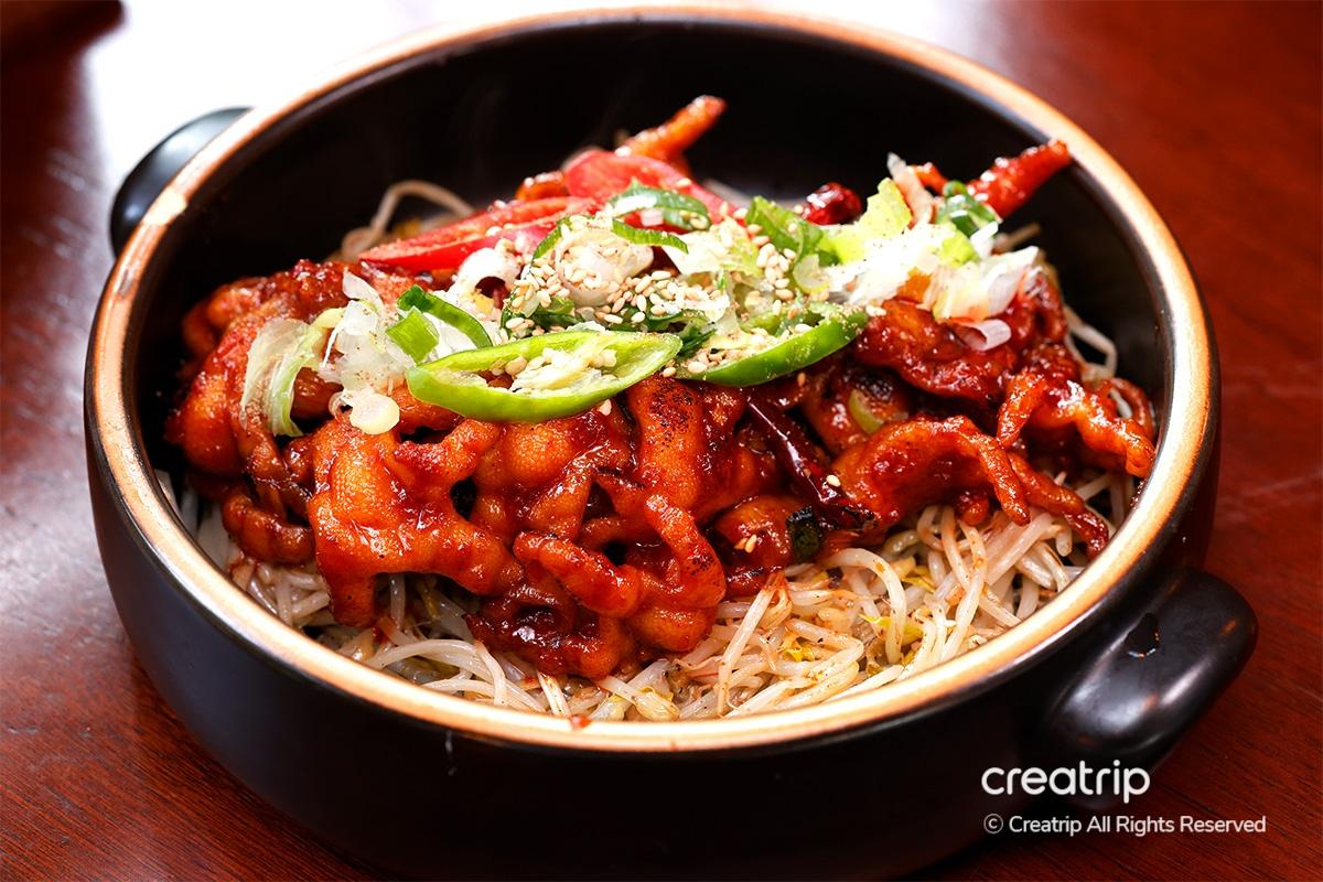 Spicy chicken feet dipped in creamy mayo sauce for a balanced bite at Earl, Hongdae.