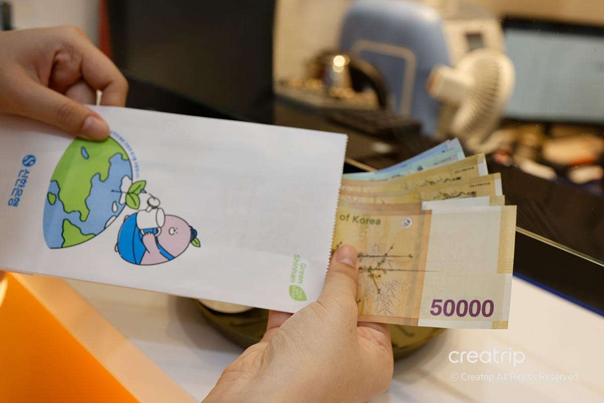 Custodire il denaro appena cambiato all'interno di una busta fornita al Mega Currency Exchange di Gwanghwamun.