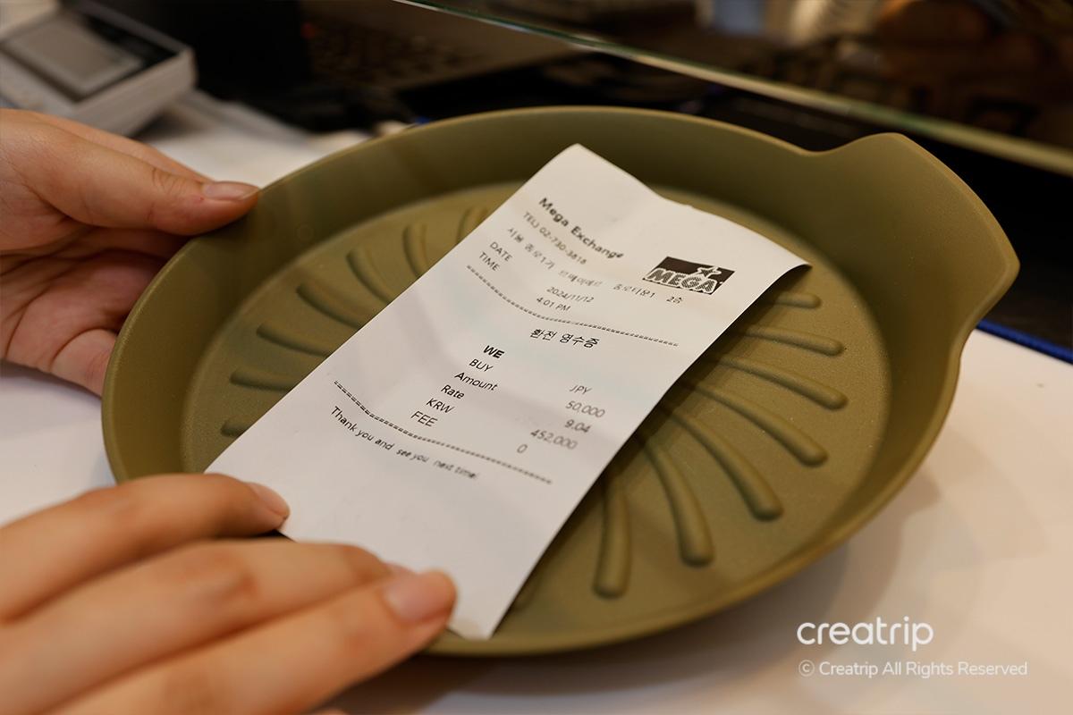 Mostra una ricevuta di cambio valuta al Mega Exchange di Seoul dopo aver cambiato yen giapponesi in won.