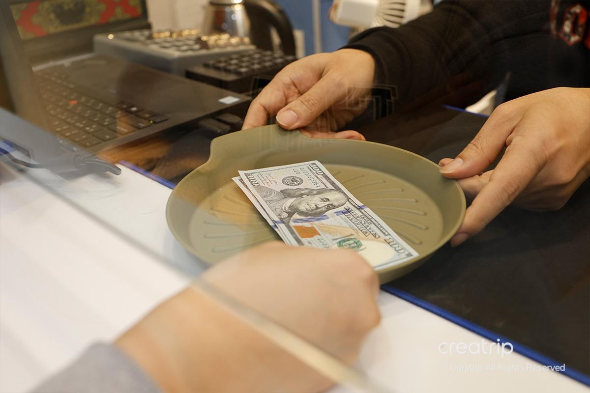 100 dollari americani posizionati sul vassoio per il cambio in won coreani presso il Mega Currency Exchange.