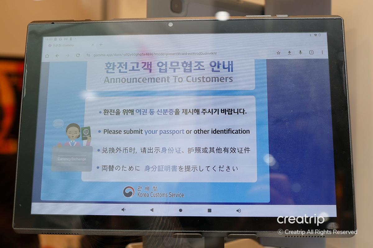 Schermo al Mega Currency Exchange che invita i clienti a presentare un passaporto o un altro documento d'identità per il cambio valuta.