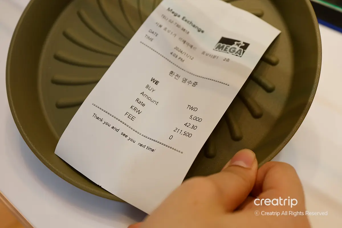 Ricevuta dello scambio di valuta al Mega Exchange di Seoul, che mostra i dettagli della transazione in won coreani.
