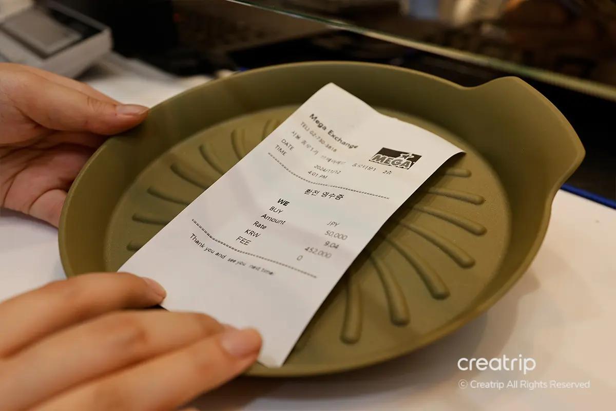 鍾路MEGA EXCHANGEのトレイに入った領収書。