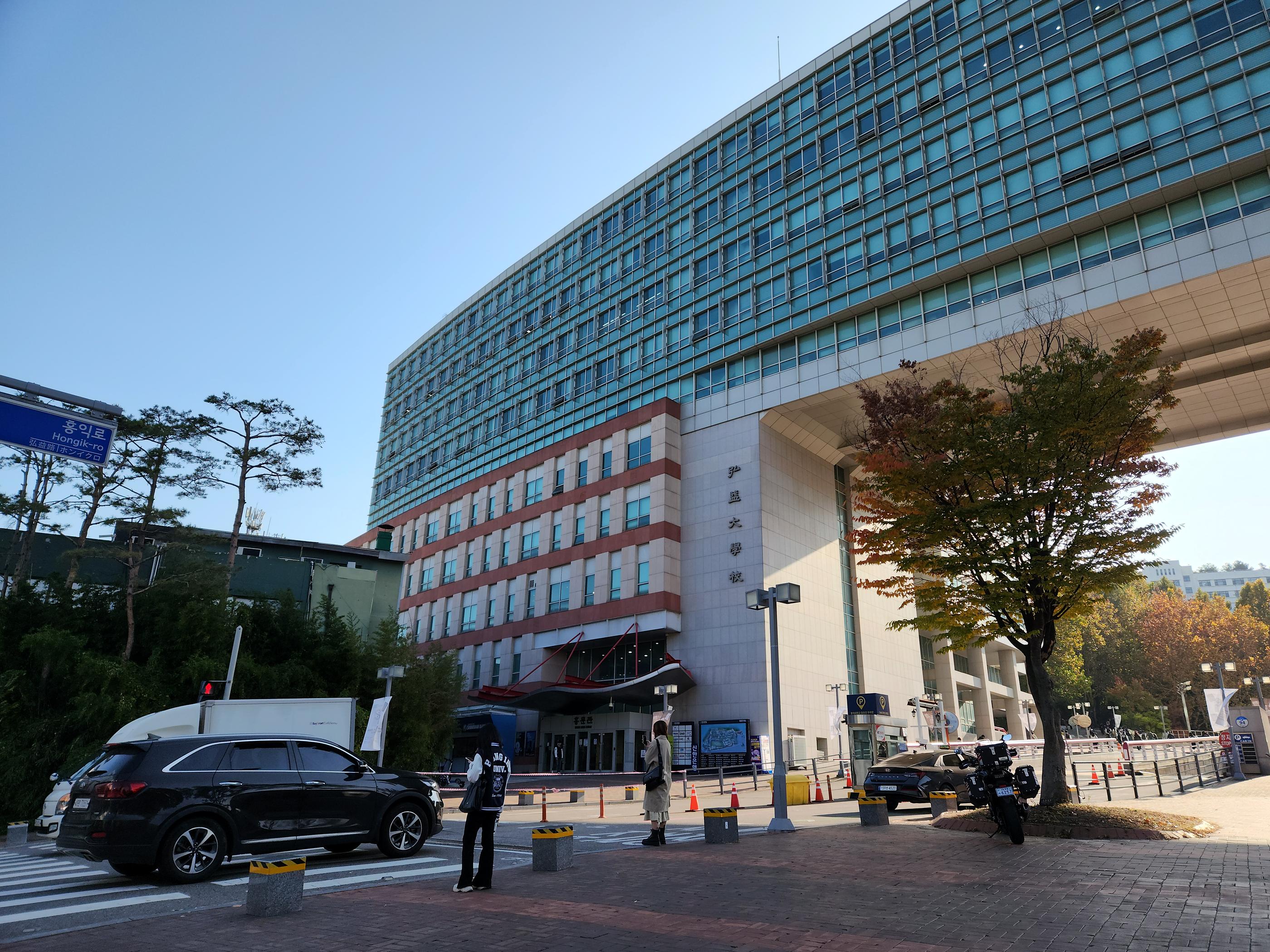 弘益大学主楼的大门，宏伟的建筑设计令人印象深刻，吸引众多国际学生前来就读。