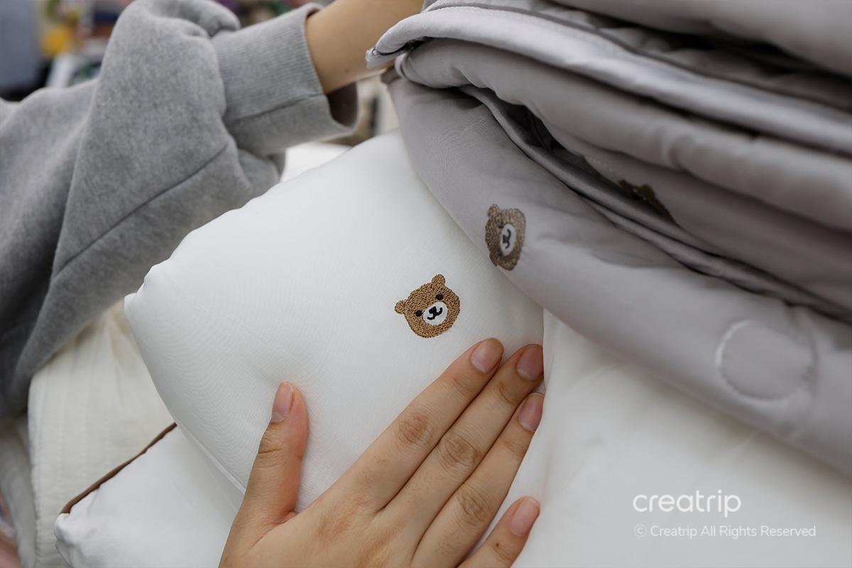 塔洞商會的白色熊圖案面料被子的特寫鏡頭，展示被子的柔軟質感和關於材質質量的信息。