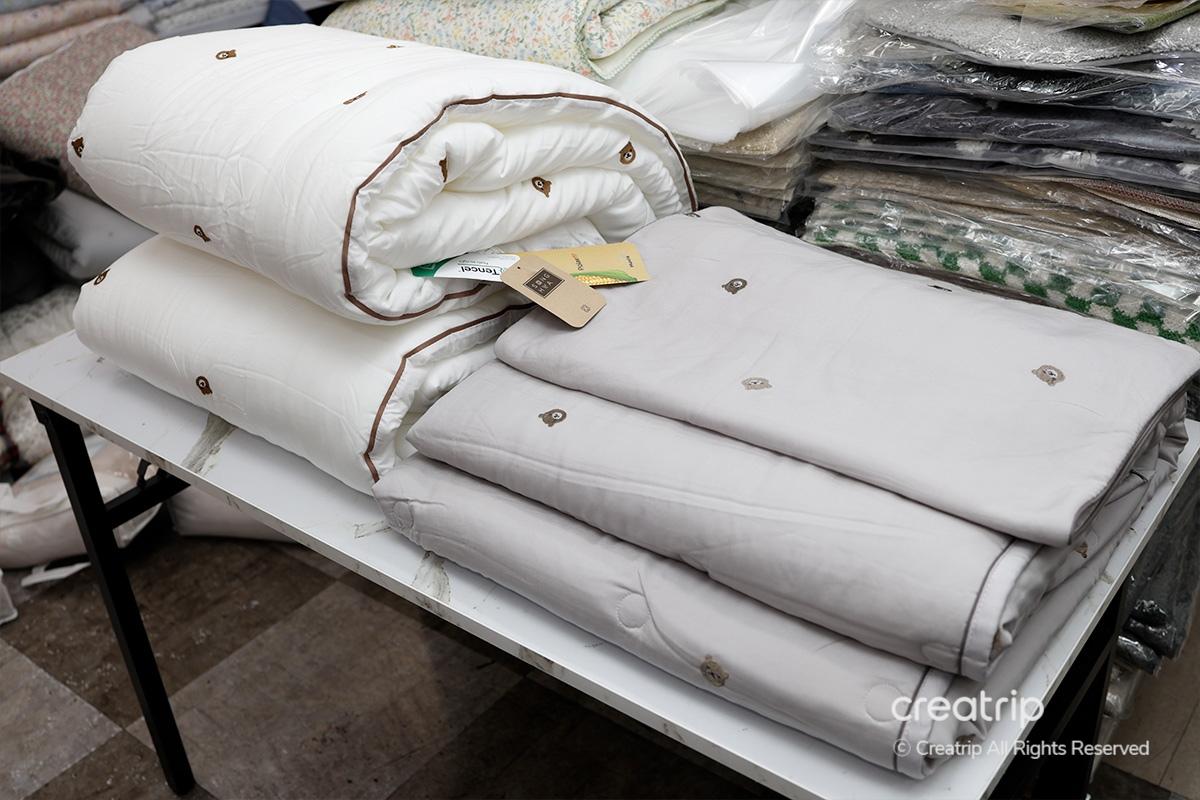 顧客在塔洞商會使用手機展示Creatrip優惠券，獲取折扣買牀品的優惠場景。