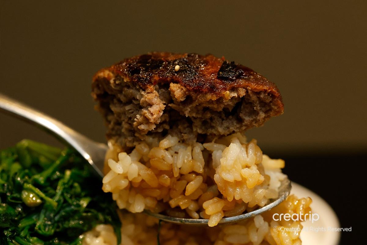 Tteokgalbi acompañado de guarniciones de verduras en JINJAK KAKII.