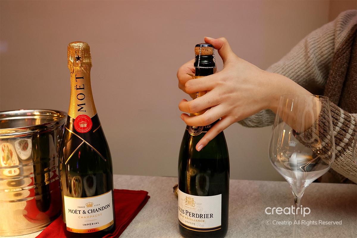 Eine Flasche Moet & Chandon wird geöffnet, um in Gläser eingeschenkt zu werden, im stilvollen Ambiente der Kemistry Weinbar.