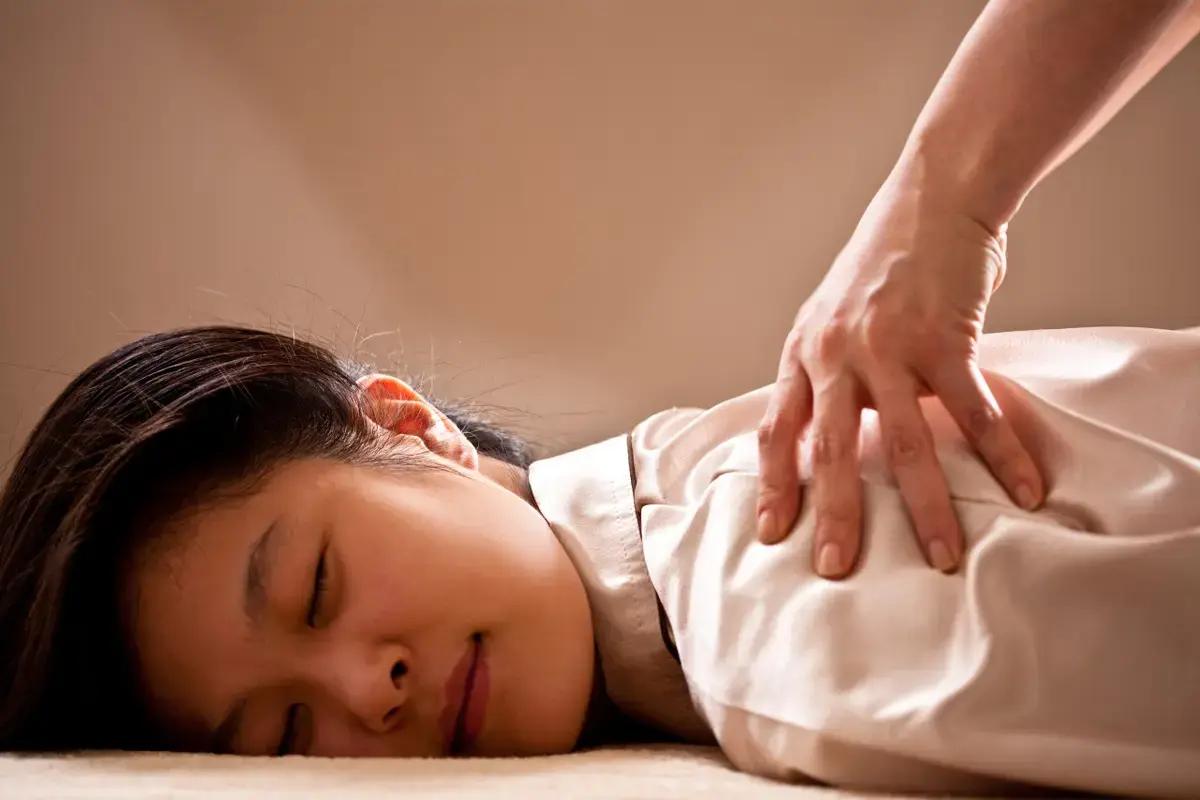 Happy Skin spa interior presenting a cozy treatment room with plush bedding.