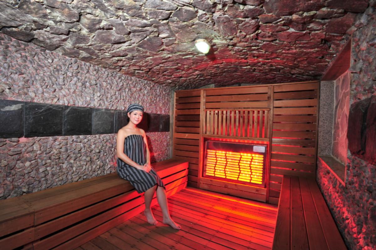 Traditional sauna room at Hana Mud汗蒸幕 with stone walls and wooden seating.