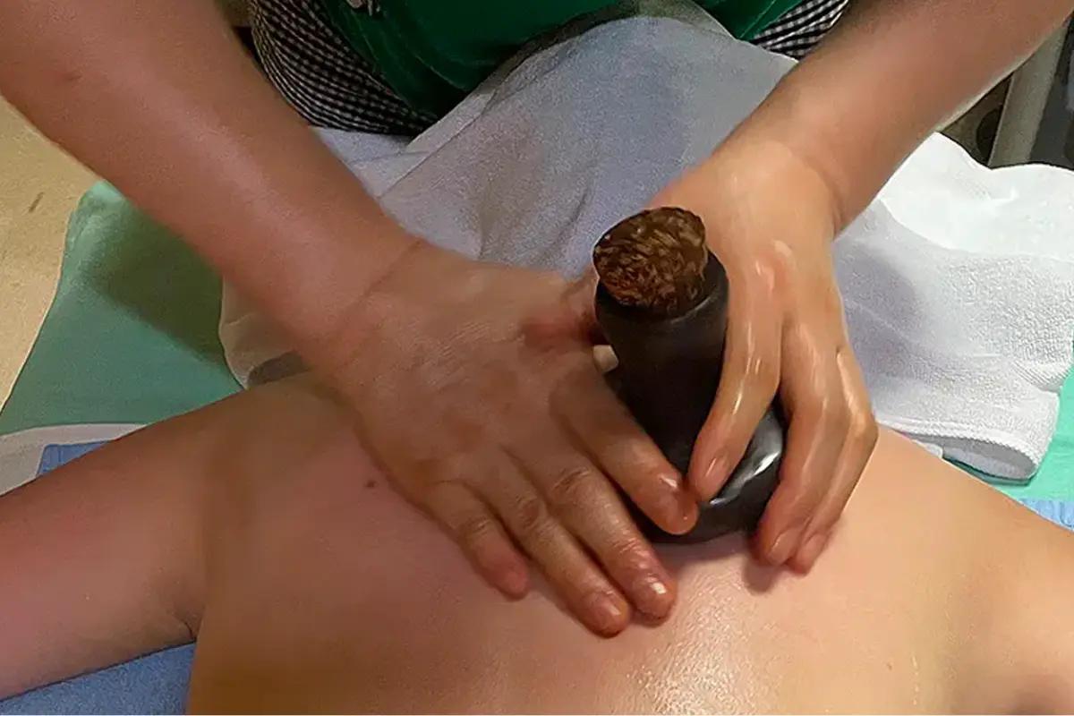 Massage therapist using traditional techniques at Soft Fragrance to alleviate muscle tension.