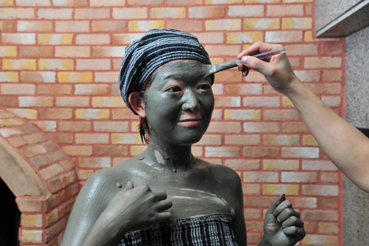 Person receiving a mud pack treatment at Hana Mud汗蒸幕 for skin detoxification.