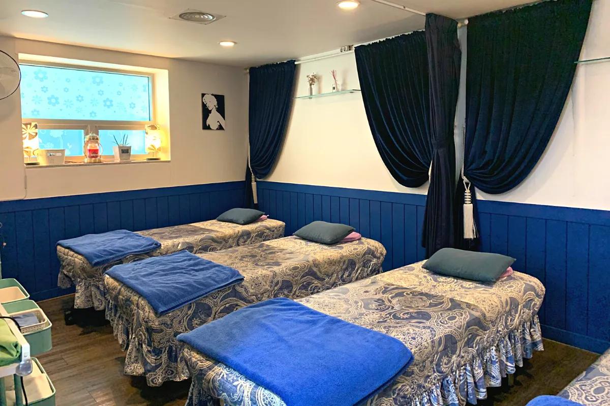 Wide view of Blue Arirang spa room showing multiple beds for group treatments.
