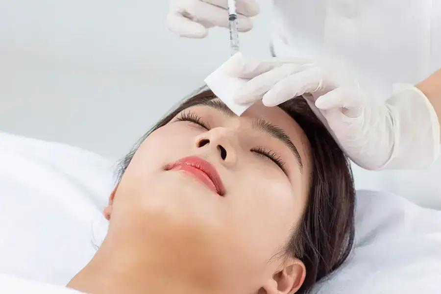A close-up inside a modern Korean factory-style skin clinic in Seoul. The clinic is designed for efficiency and cost-effectiveness in dermatology treatments.