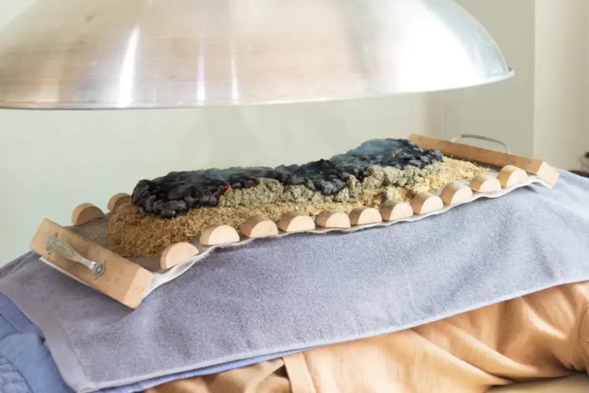 お腹やツボを温めるお灸治療の様子