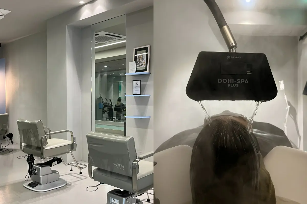 Modern hair salon interior and scalp treatment: two salon chairs with mirrors on the left and a client lying back under a steaming Dohi-Spa scalp treatment device on the right.