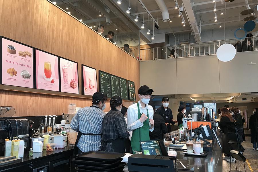 workers behind checkout counter at Starbucks Seoul Wave Art Center 