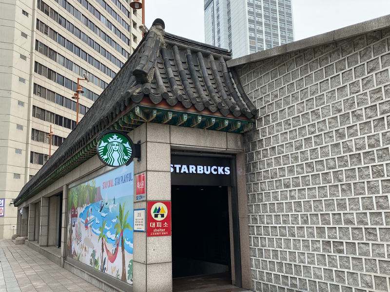 hanok style starbucks (starbucks reserve hwangudan) side view of traditional style roof and starbucks sign with logo