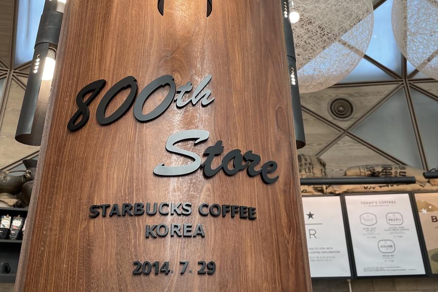 8000th store sign on wooden pillar at starbucks reserve famille park 