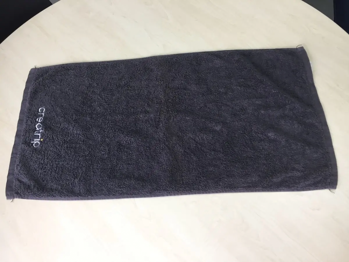 韩国汗蒸幕羊头巾折叠步骤一，摊开毛巾至桌面，准备制作可爱羊头巾样式。