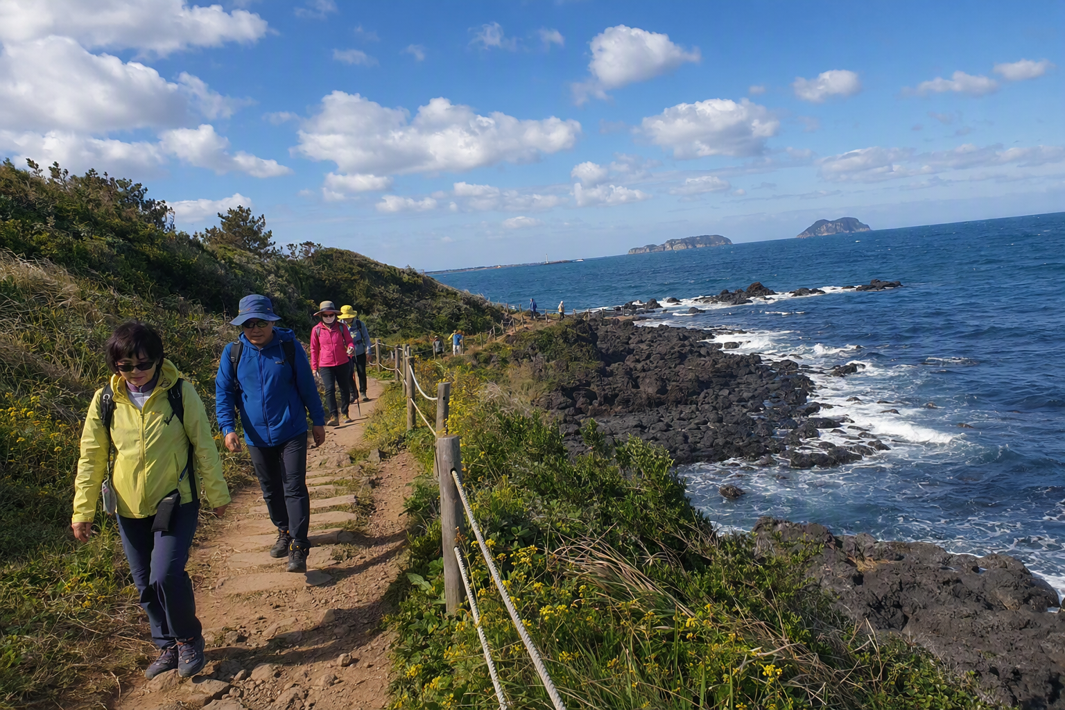 Photorealistic bright image of Jeju coastal Olle trail with walkers, volcanic rocks, blue ocean, distant islets, spring sunlight, no text