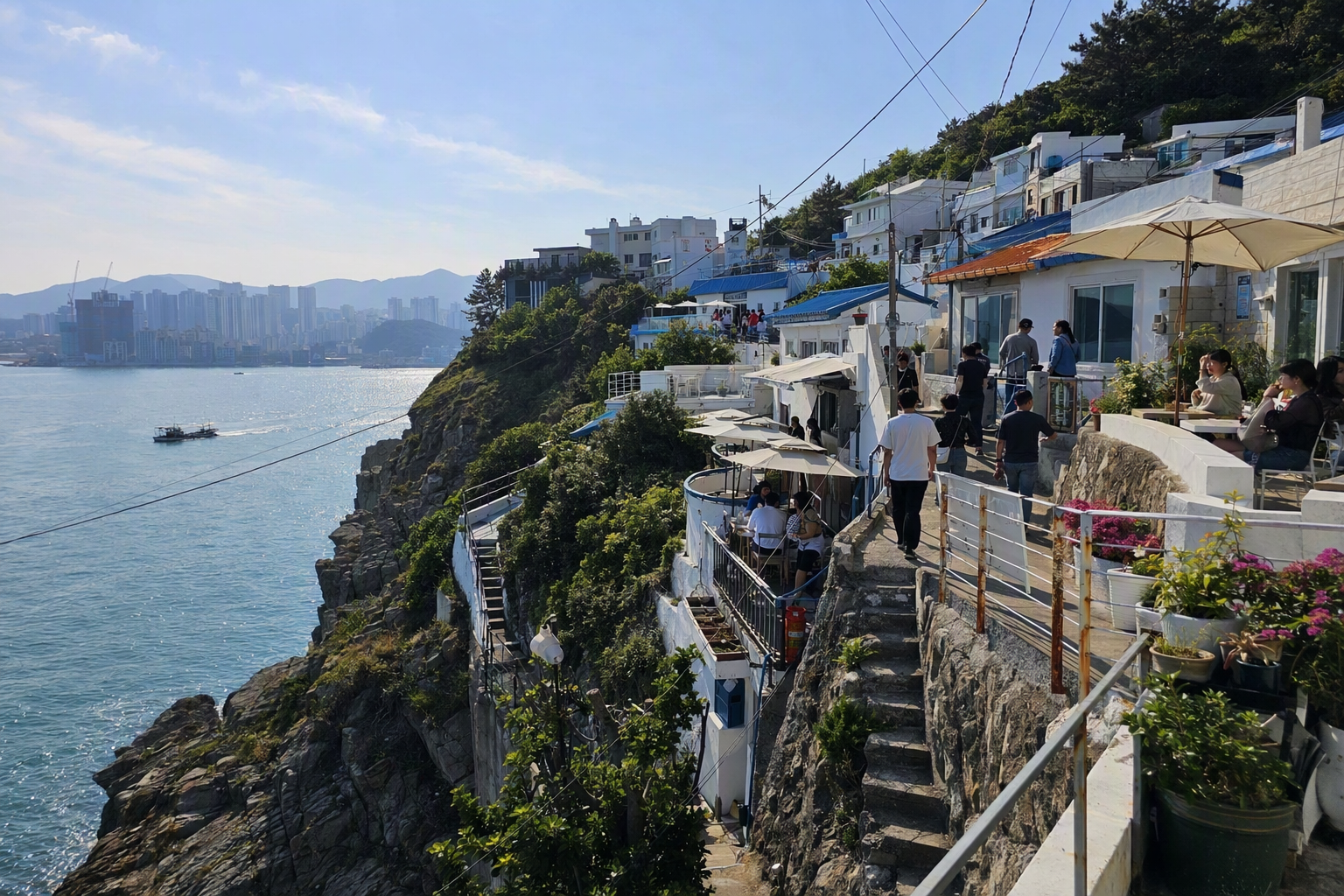 Bright vibrant photorealistic cliffside coastal village in Busan with white houses, blue ocean, cafe terraces, afternoon sunlight, calm travel mood, no text