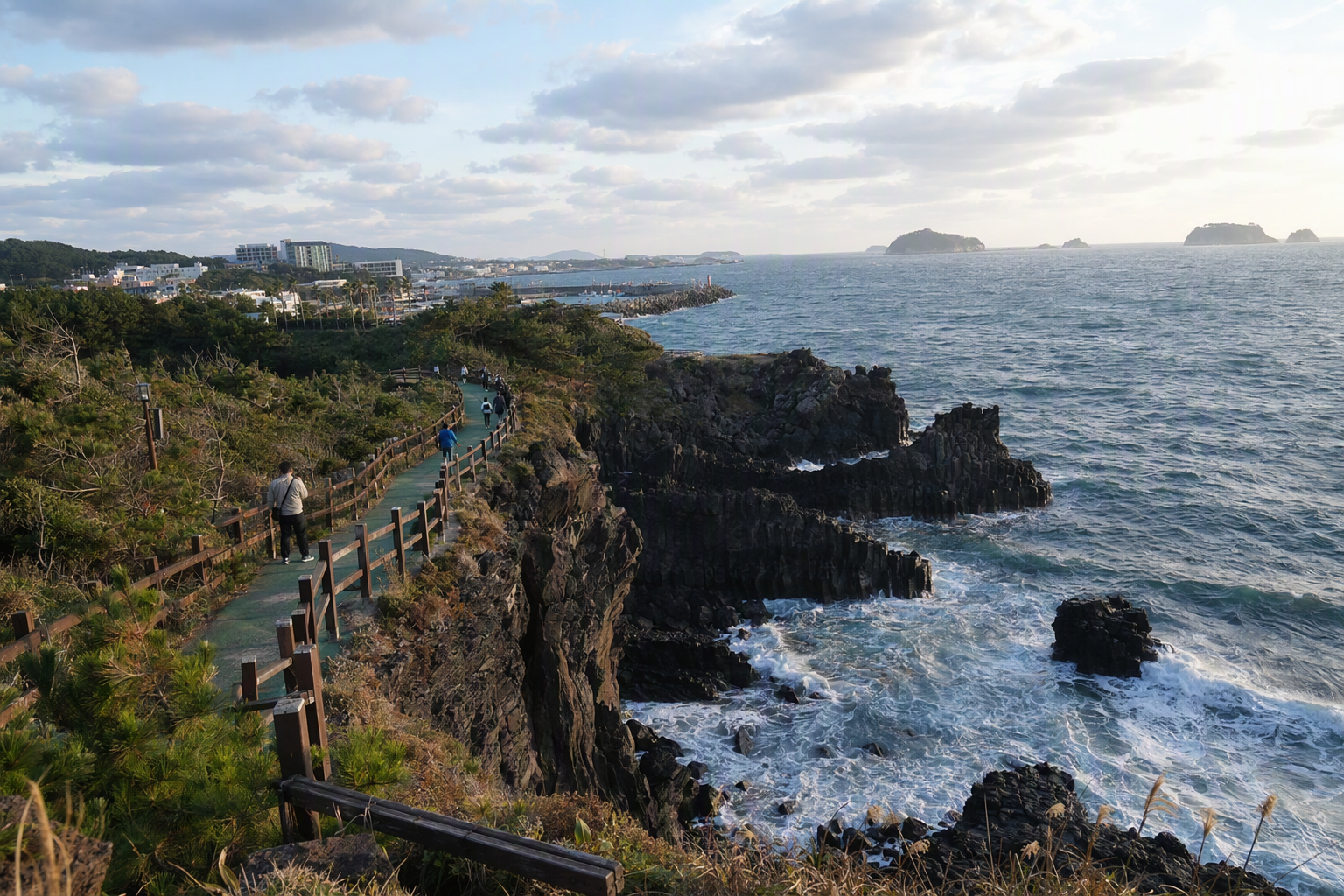 Bright photorealistic panorama of south Jeju coastline with basalt cliffs, deep blue sea, green walking path, and warm afternoon light, no text