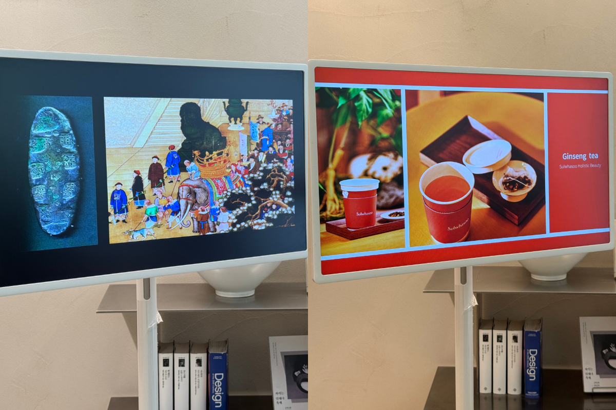 Two display screens at Sulwhasoo Bukchon House showing brand content, with traditional artwork and antique objects on the left screen and ginseng tea with teacups on the right screen.