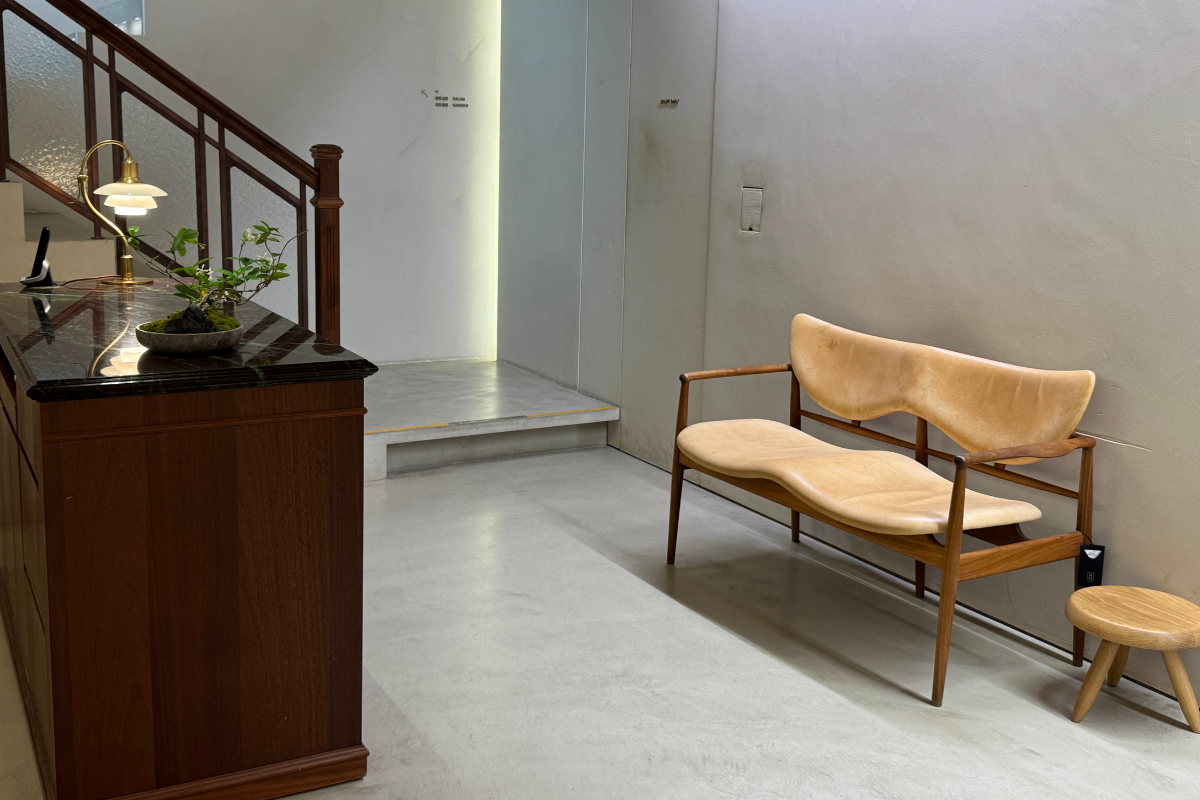 Khu tiếp tân Sulwhasoo Bukchon House với quầy gỗ, đèn bàn cổ điển, cầu thang, và ghế băng cong bằng gỗ trong không gian hanok phong cách hiện đại.
